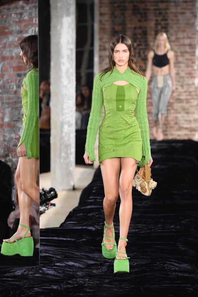 Frau im grünen Kleid und in grünen Plateauschuhen