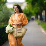 Frau um orangefarbenen Leinenkleid
