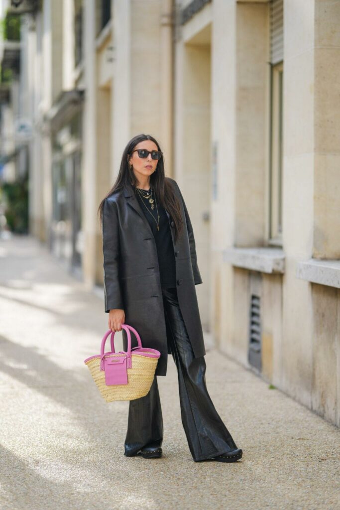 Frau in einem schwarzen Total-Look mit einer Korbtasche