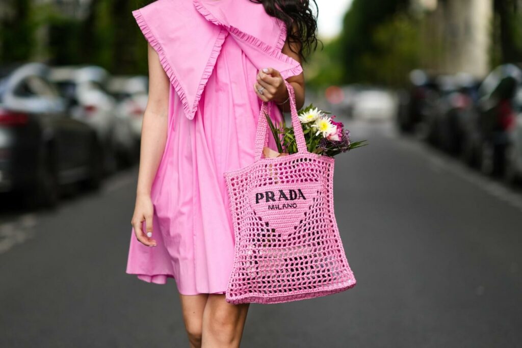 Frau in einem rosafarbenen Kleid und mit einer rosafarbenen Handtasche
