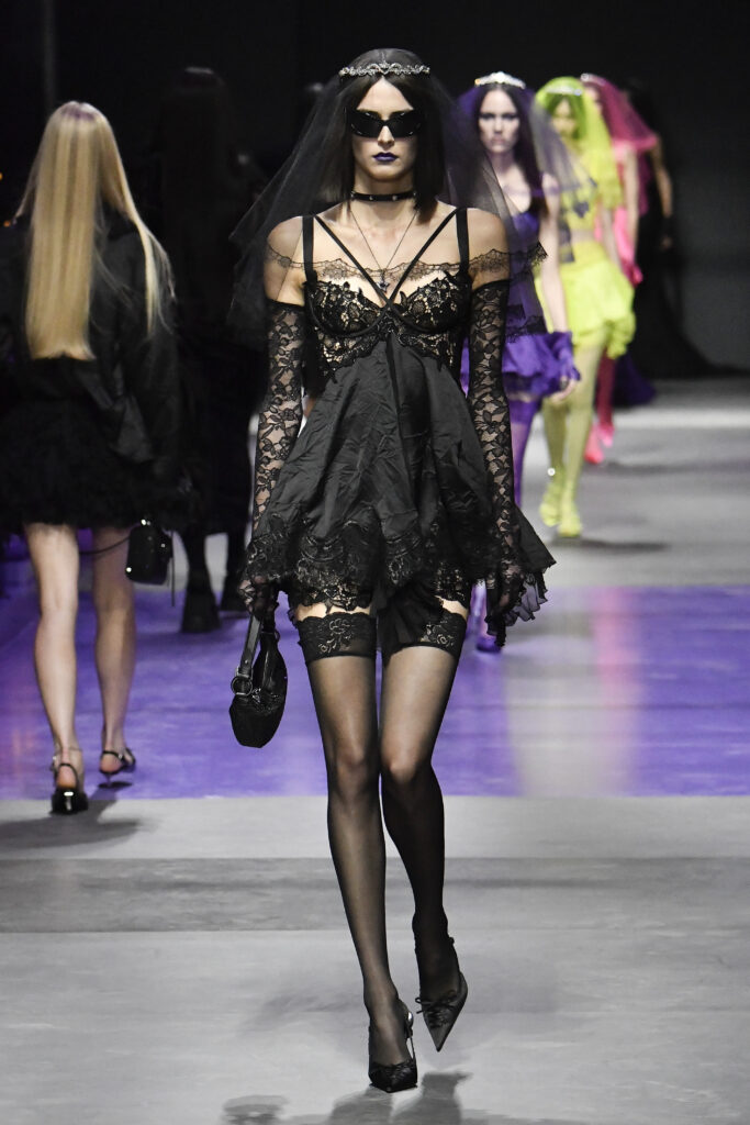 Frau auf dem Laufsteg im kurzen, schwarzen Kleid im Gothic-Style