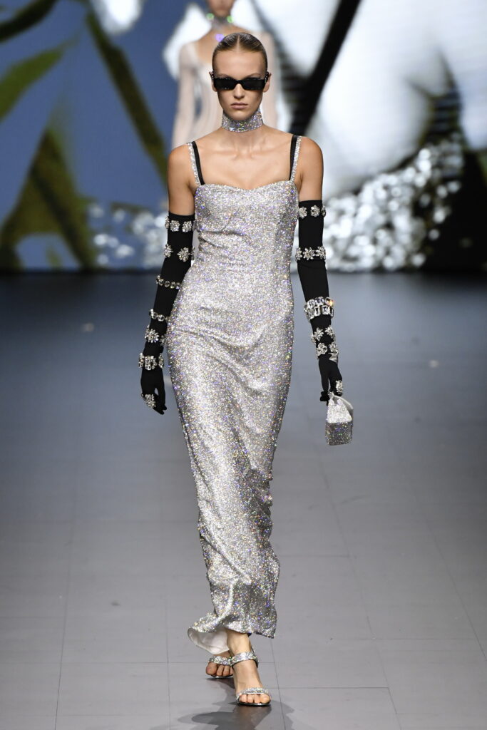 Frau auf dem Laufsteg im langen, silberfarbenen Kleid von Dolce & Gabbana