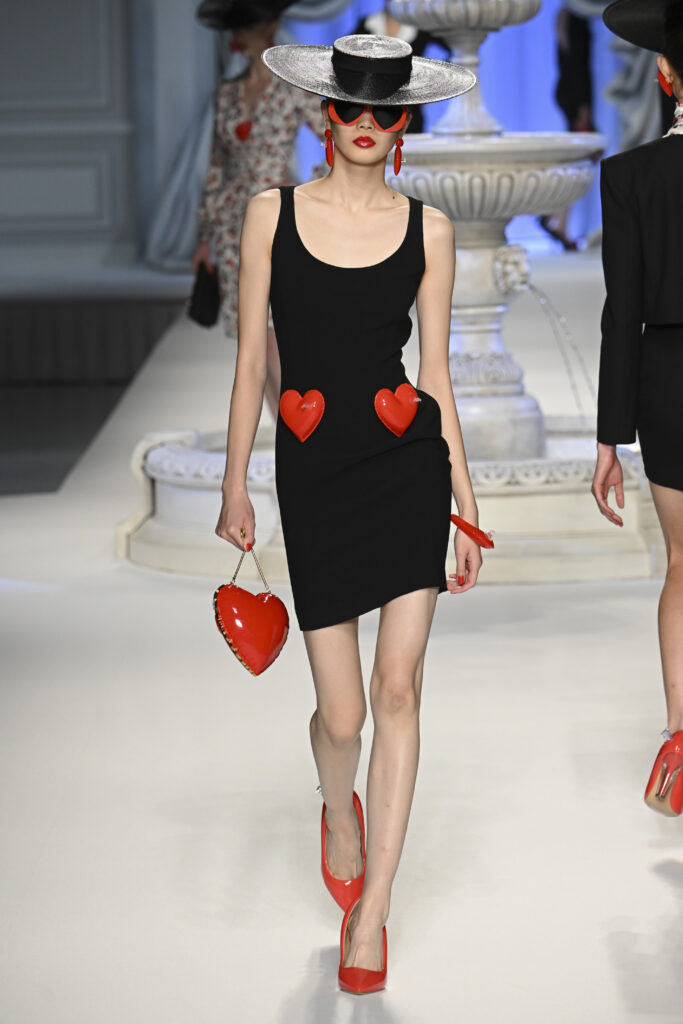 Frau auf dem Laufsteg im schwarzen Kleid mit Herzen von Moschino