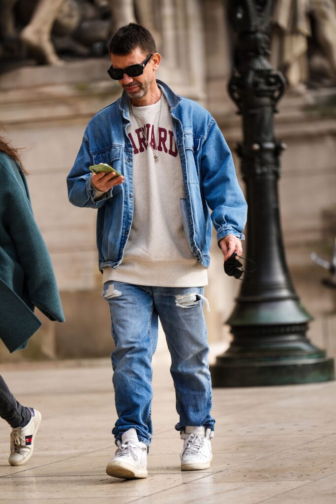 Mann in einer Jeansjacke, Jeanshose und einem Sweatshirt