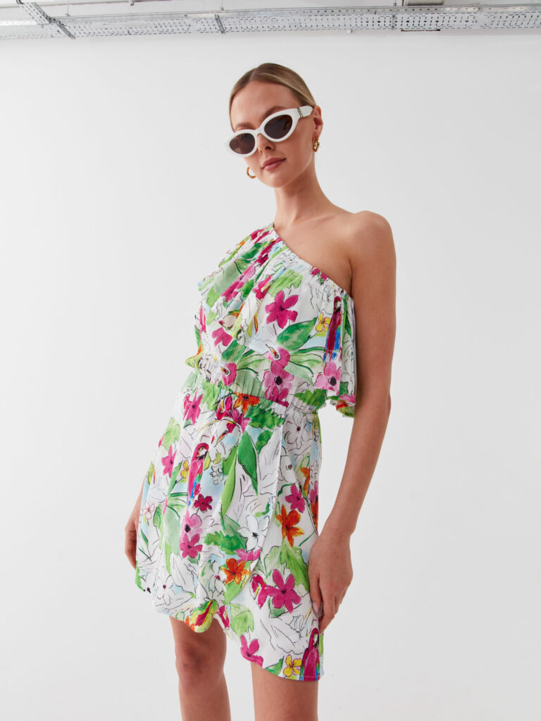 Model in einem asymmetrischen Kleid mit floralem und tropischem Muster