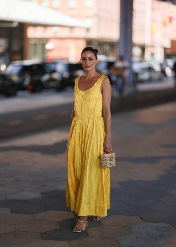 Frau in einem gelben Maxikleid und silbernen Sandalen