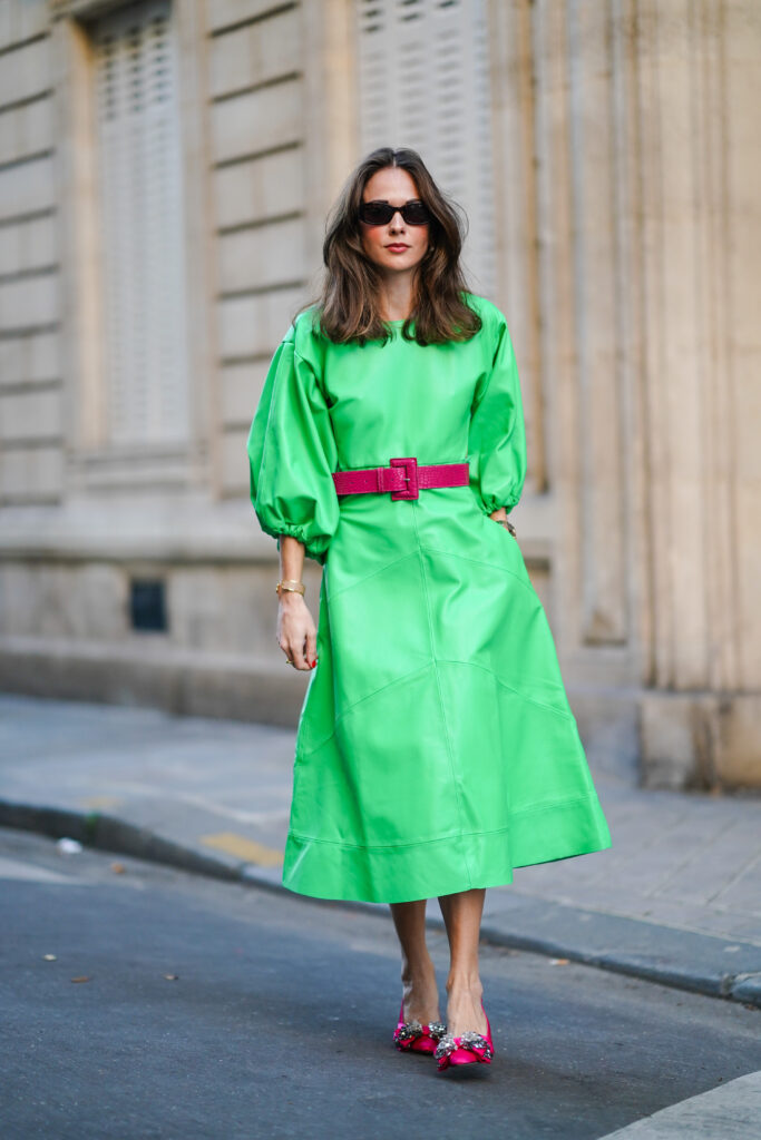 Eine Frau in einem mintgrünen Kleid und fuchsiafarbenen High Heels