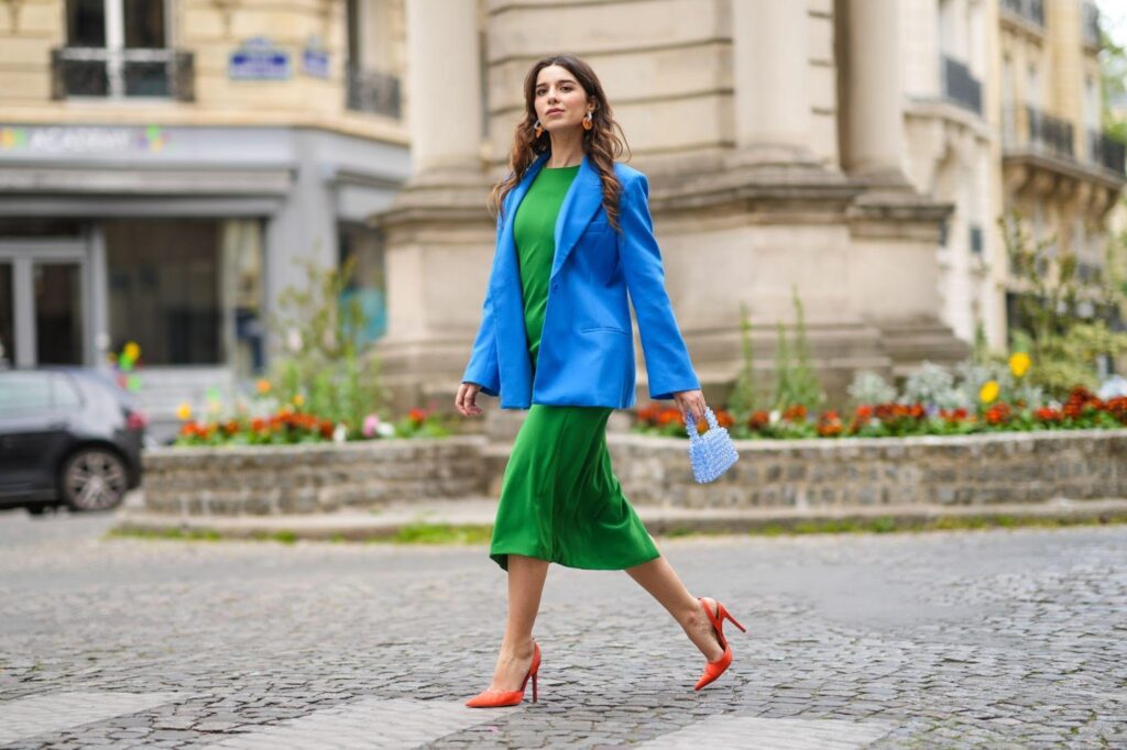 Frau im grünen Kleid und in orangefarbenen High Heels