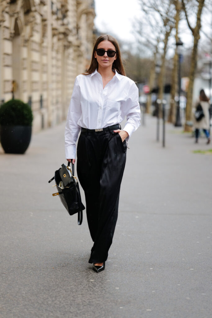 Elegant gekleidete Geschäftsfrau in einem weißen Hemd mit einer Aktentasche