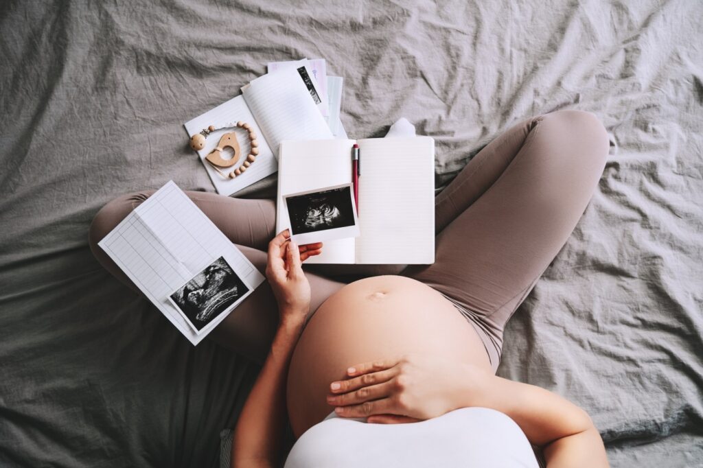 Schwangere Frau sieht sich Ultraschallfotos an